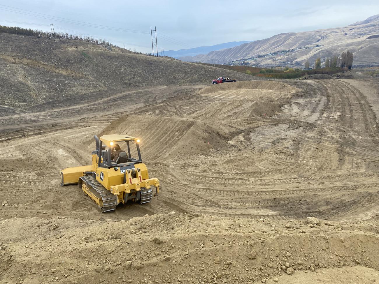 Dozer shaping a large hillside earthwork site